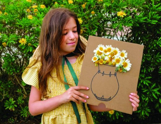 Menina com jarra de papelão na mão