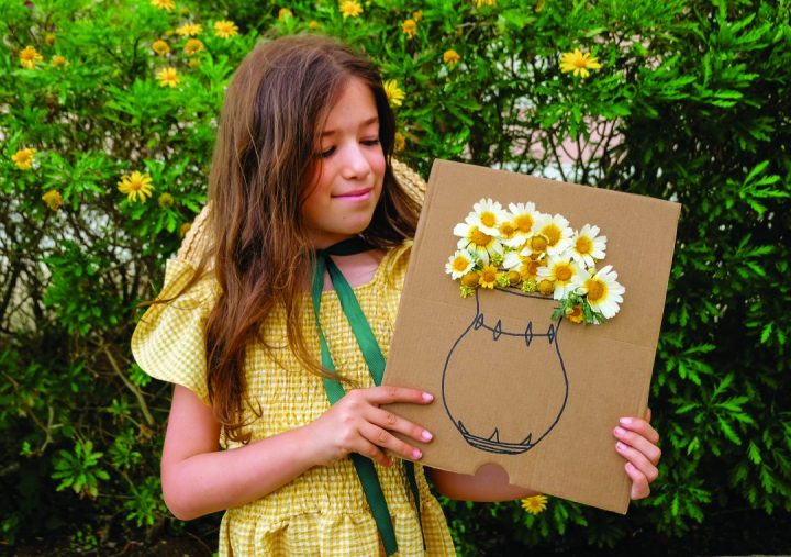 Menina com jarra de papelão na mão